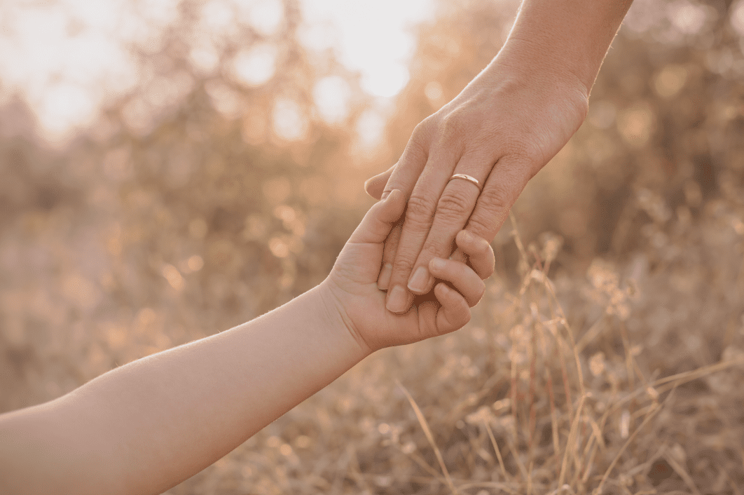 Mama und Kind geben einander die Hand